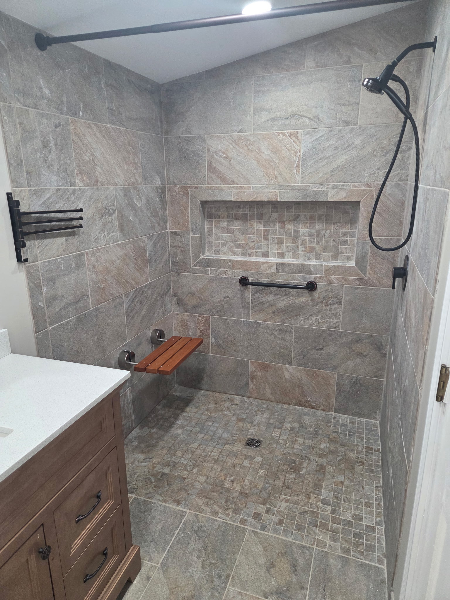Completed tile shower with recessed niche and folding seat